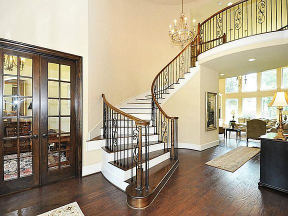 Beautiful entry has soaring ceilings with unique ceiling detail. Elegant curved staircase makes a gr