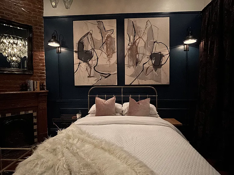 Comfortable queen-sized bed with large, vintage crystal chandelier