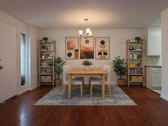 Open dining area with chandelier _ flows directly into the living room and kitchen (virtually staged)
