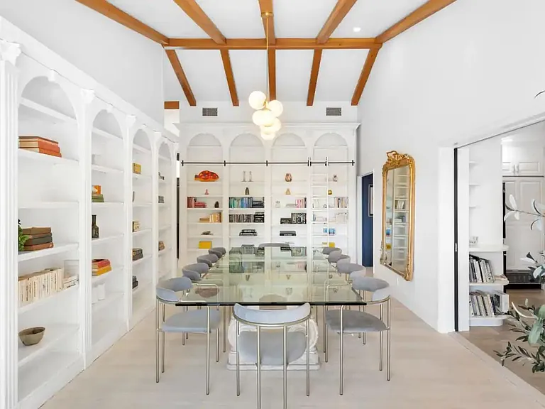 Formal dining area with a timeless design lined with books and unique art.