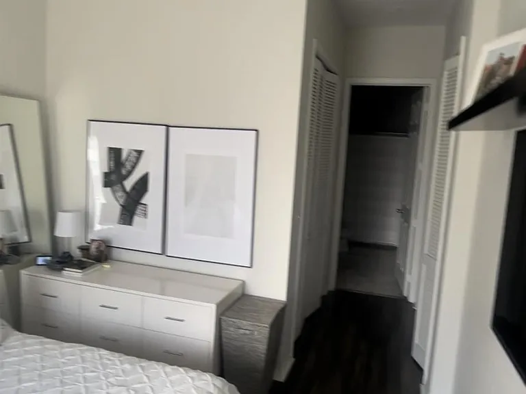Master bedroom view down hall with two ceiling height closets on each side Into master bath