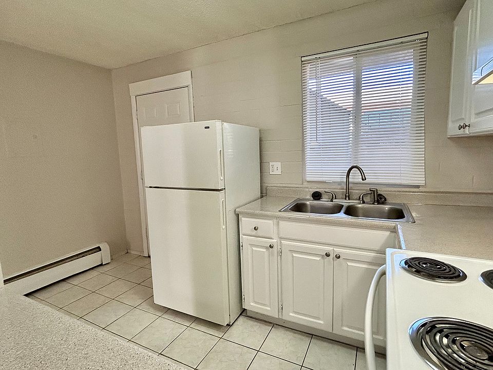 Inviting kitchen space with modern white cabinets, double sink, and abundant natural light.