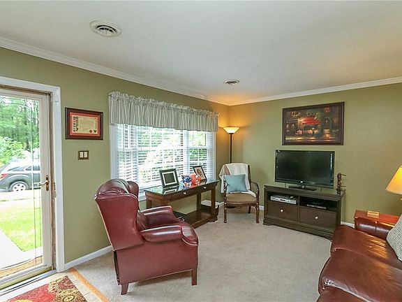 Front door opens up to an inviting living room. Note- the walls have been painted a neutral grey color and the carpet has been replaced with luxury vinyl wood plank flooring. (See next pic).
