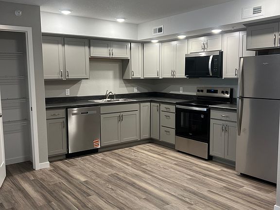 Kitchen with stainless steal appliances, electric gas top stove and pantry.