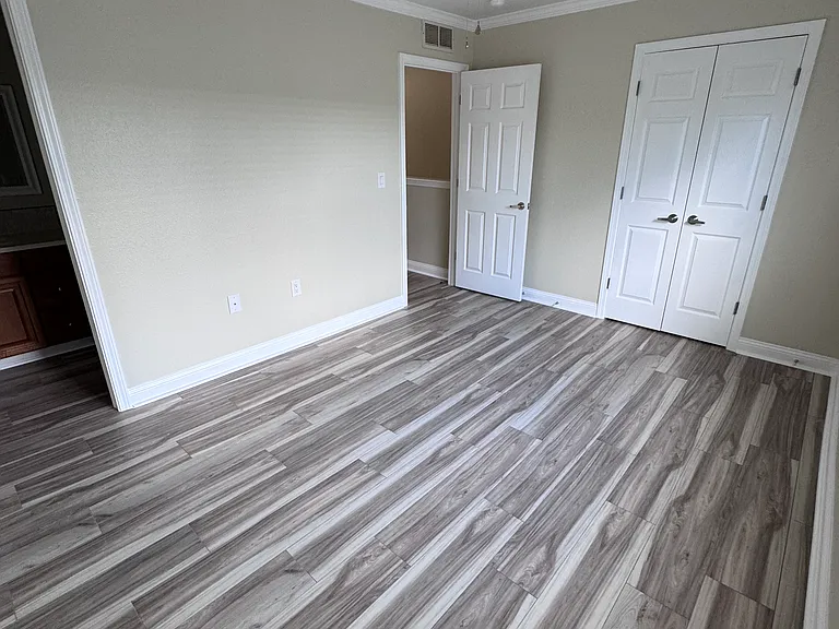 Guest bedroom with it's own bathroom on the left and closet with double doors on the right.