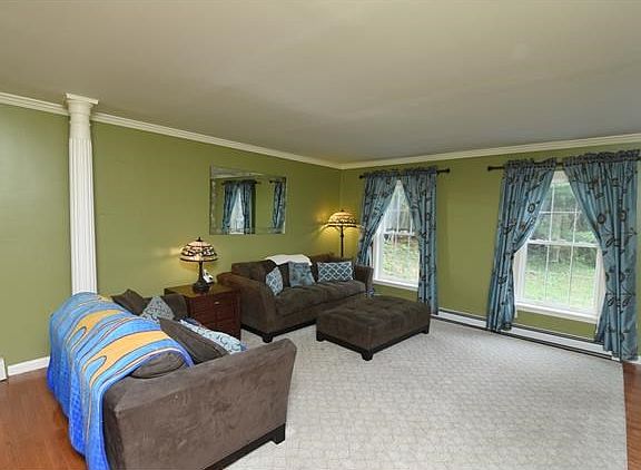 Living room is accented with crown molding and ceiling to floor columns.