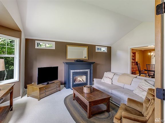 The formal living room features a gorgeous fireplace, bay windows, vaulted ceilings and open sight lines to the dining room.