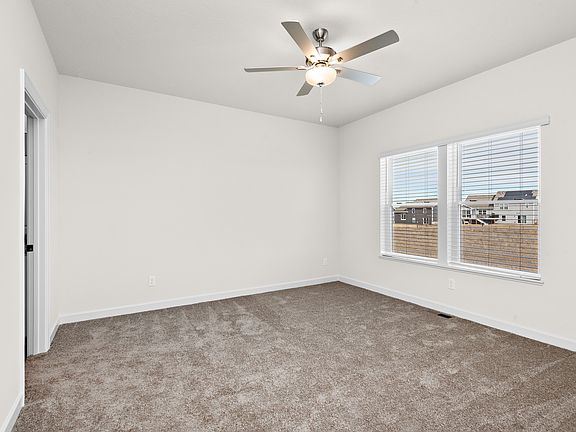 The master bedroom has a large window and carpet.