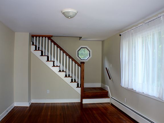 The living room area is freshly painted and features hardwoo