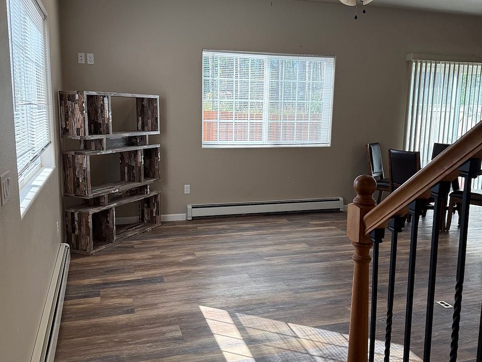 Living room with ceiling fan and recessed lighting. Sliding glass door off of living room leads to deck and back yard.
