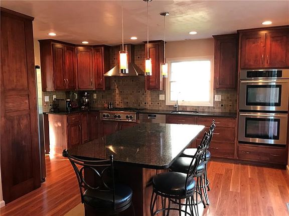 Custom Amish built cabinets, cherry stained maple. Custom tile back splash. Stainless appliances. Double electric ovens with con