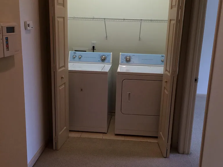 Upstairs laundry closet with washer and dyer. Upstairs hallway leads to bedrooms and full hall bath.