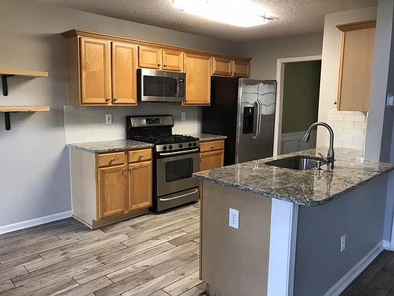Galley kitchen with granite counter tops and stainless steel appliances