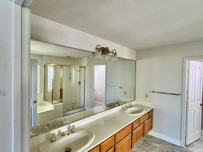 Spacious primary bedroom ensuite bathroom featuring dual sinks