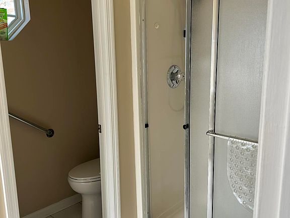 walk-in shower with spray nozzle and separate garden tub, split vanity area