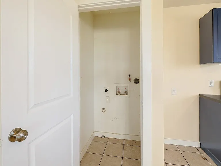 Laundry closet comes equipped with a stackable washer and dryer.