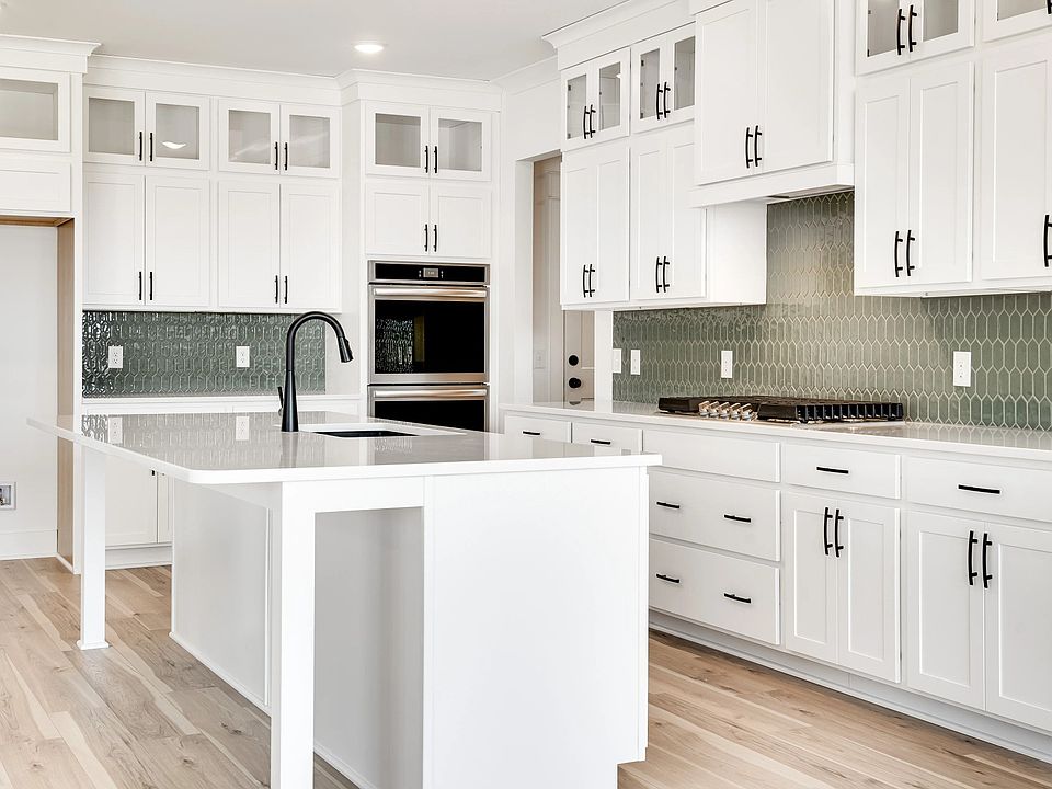 Exquisite white cabinetry and chic green backsplash define this Northridge Park kitchen s elegance a