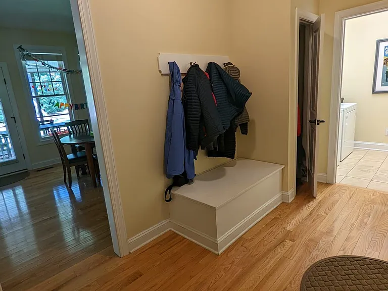 The mudroom opens to the attached garage, laundry room, kitchen with seating area, and formal dining room. It has a cost closet and a broom closet.