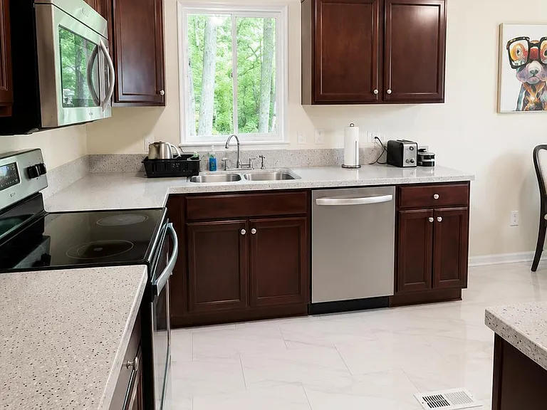 Well-equipped kitchen with ample cabinet storage, generous counters, and stainless steel appliances including dishwasher.