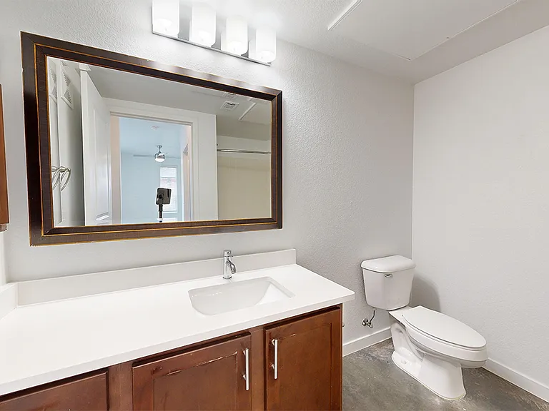 Apartment bathroom with large soaking tub and wood-style flooring.
