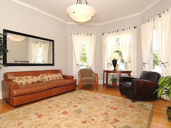 Living room: High ceilings, hardwood floors, 3 window bay