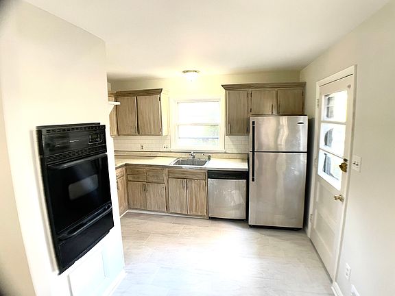 All new large format gray ceramic tile. Distressed antiqued cabinet design with new brushed nickel hardware and drawer pulls. Small island for additional countertop workspace and storage can be provided.
