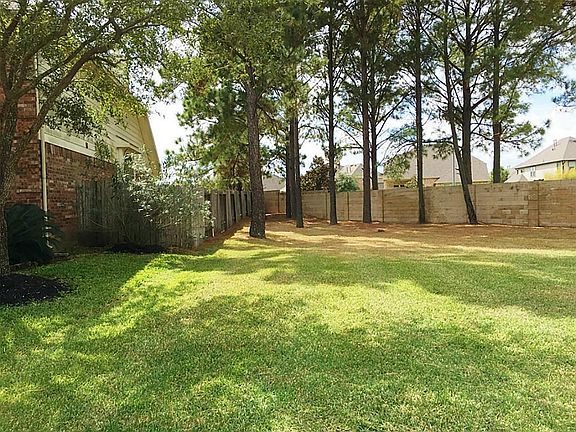 The home sits next to a green space with lots of mature tree