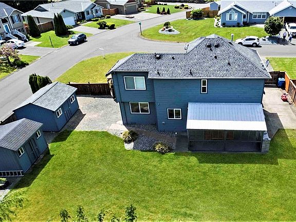 View of back yard showing off 2 of the 3 outbuildings, the covered & enclosed back patio and RV/boat pad on the right!