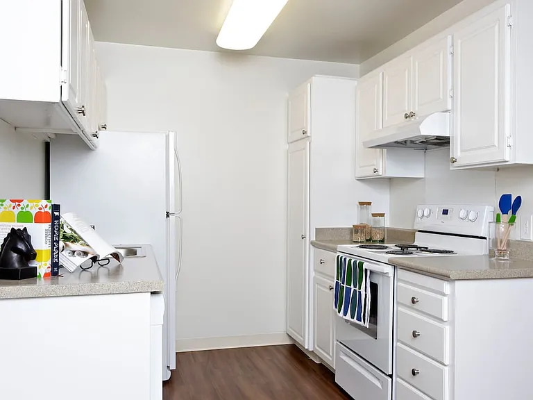 Classic Package I kitchen with white appliances, white cabinetry, beige laminate countertops, and hard surface flooring
