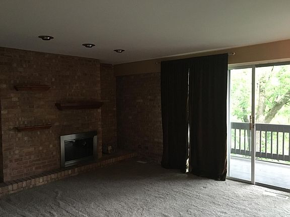 Living room w/ exposed brick fireplace