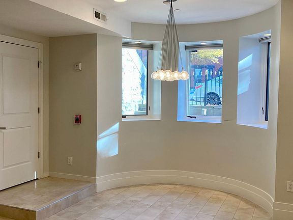 entry and rounded turret with three East-facing windows, modern chandelier