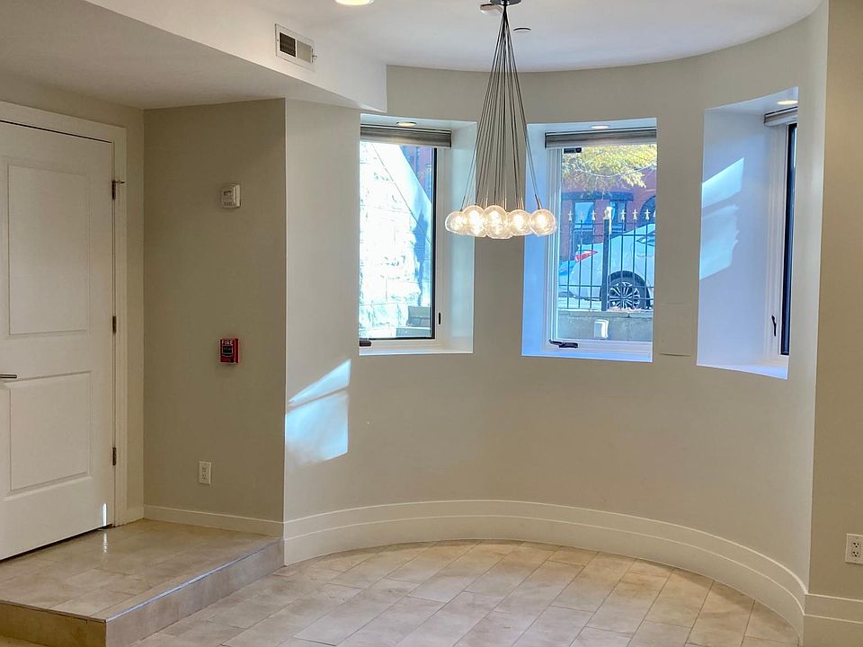 entry and rounded turret with three East-facing windows, modern chandelier