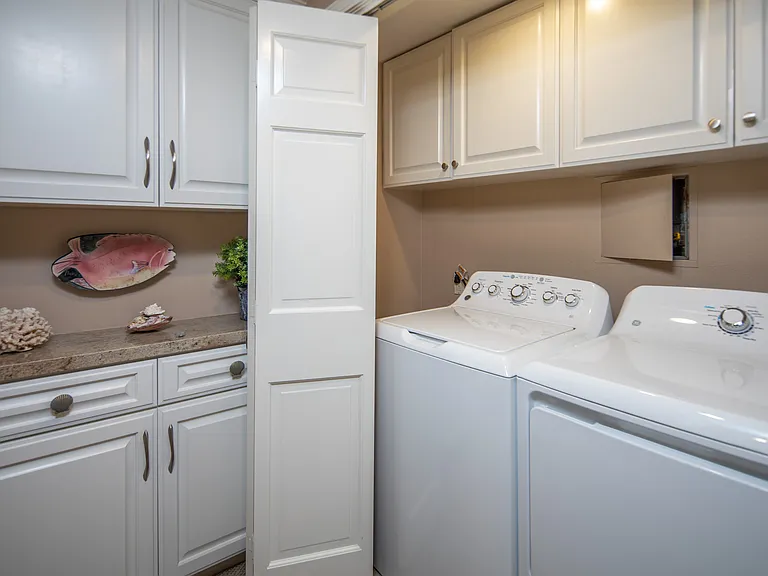 Laundry room located near entry way of unit