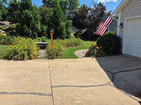 Cobblestone walk to exterior trash can enclosure.