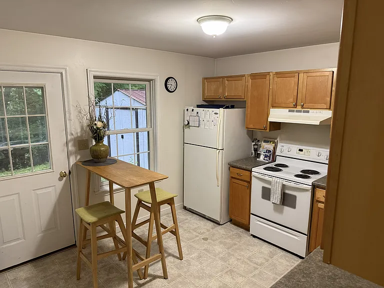 Kitchen includes stove, dishwasher, and refrigerator. Entry to back yard from kitchen.