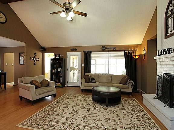 Large family/living room with hardwood floors and vaulted ceiling.