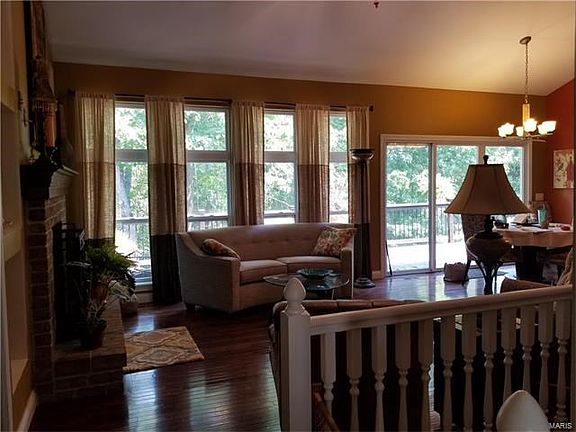 Another view of the great room with fireplace, wood floor & lots of windows!