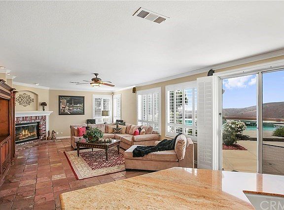Family room is open off the kitchen with beautiful built-in entertainment cabinet, and corner fireplace. Look at the Views off the Kitchen and Family room of the pool and the Canyon.