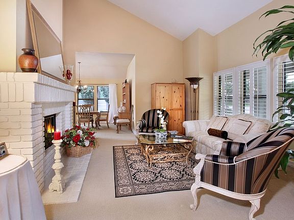 Formal Living Room with brick fireplace leads onto Dining Room