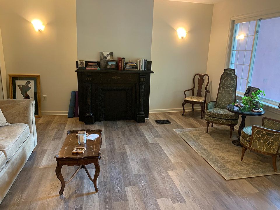 Living room with large front window and basement access. Furniture not included.