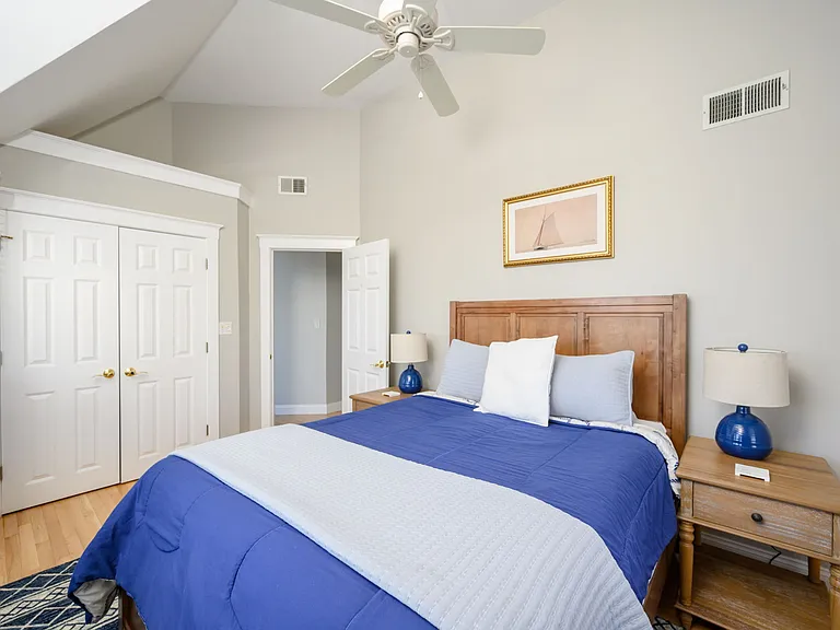 Left front bedroom with queen bed, vaulted ceiling, large closet, ceiling fan, and view of the ocean.