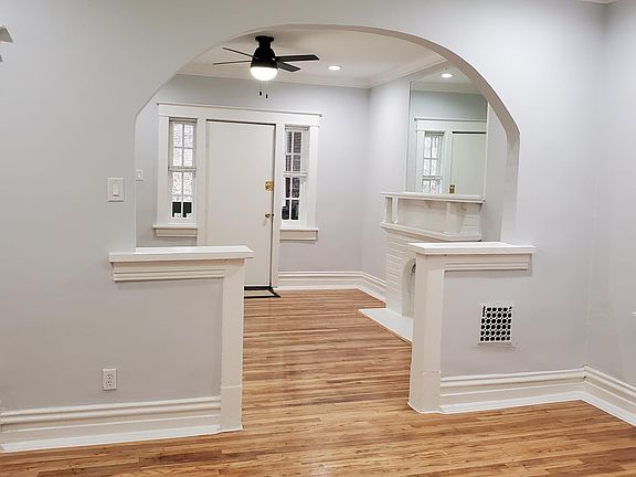A view of the front 2 rooms with archway and historic hardwood floors, new ceiling fans, can lights in both rooms on separate switch