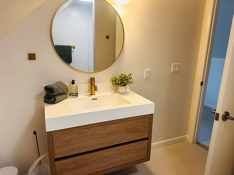Upstairs bathroom with floating vanity and walk in shower.