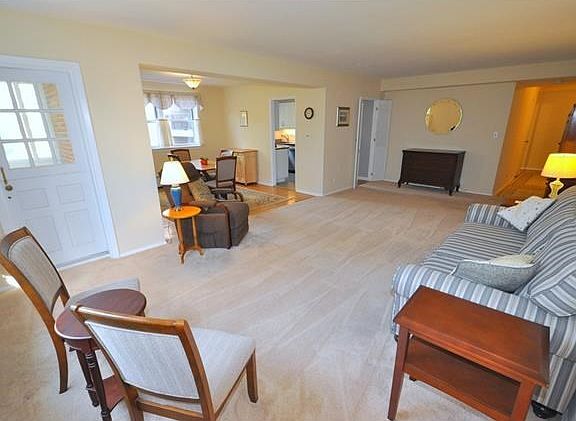 Large living room with golf course views and "L" shaped dining room. The living room has covered har