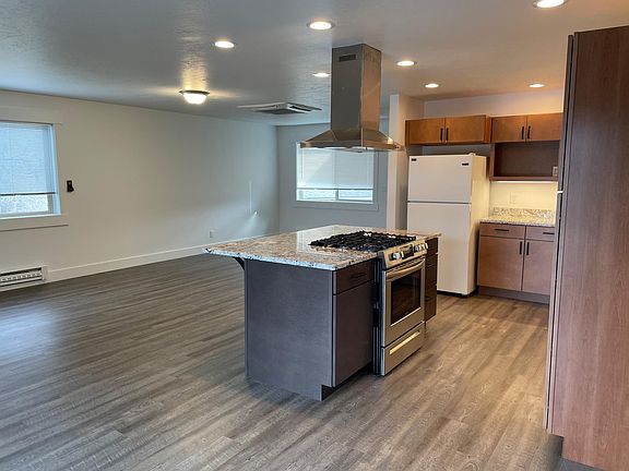 Living room off of kitchen. The refrigerator has been replaced with a stainless steel refrigerator.