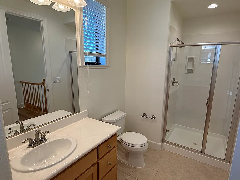 Third floor hallway bathroom features a shower stall and a storage cabinet.