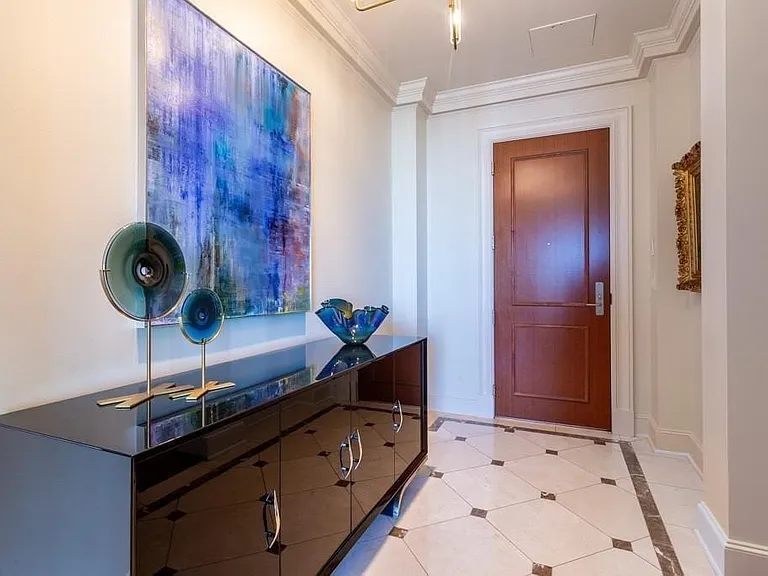Crema Marfil marble entry inlaid with Light Emperador marble.
