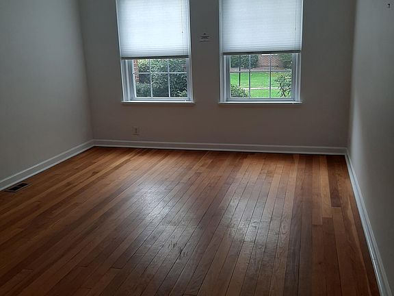 Living room first floor with outside view to surrounding gardens. Morning sunsets at living and bedroom. Original wood floors well kept. Living room separated from dinner area.