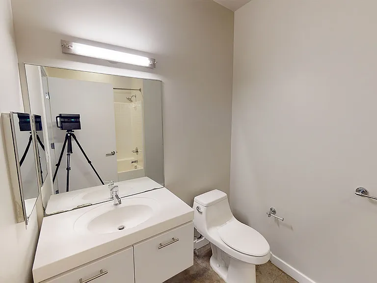 Apartment bathroom with polished concrete flooring.