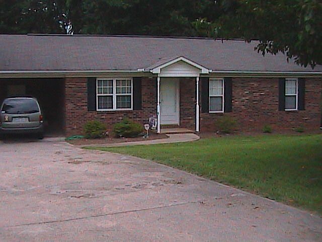 Front of house, a cement parking pad to the left
